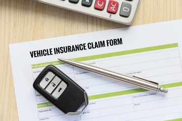 Wall Mural - Vehicle insurance claim form concept with car key and calculator