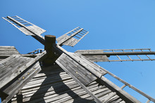 Vintage Wooden Windmill Sails Over Clear Blue Sky