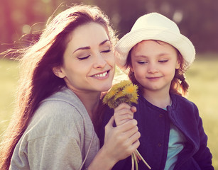 Cute daughter present her mother the yellow flowers and happy mo