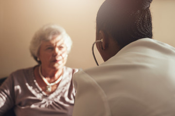 Wall Mural - Female doctor examining senior patient