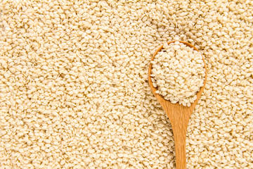 close up sesame in wooden spoon on white sesame seeds surface te