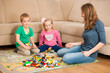 © Samo Trebizan - Children and their mother are playing with blocks on the ground