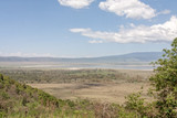 Fototapeta Sawanna - View on huge Ngorongoro caldera (extinct volcano crater) with large lake from cleft against blue sky background. Great Rift Valley, Tanzania, East Africa.
