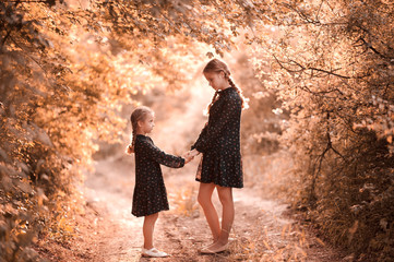 Canvas Print - Two girls holding hands standing outdoors. Togetherness. Childhood.