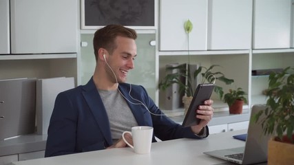 Aufkleber - Man using app on touch screen tablet. Guy happy and smile in his office. He says hi and talking with client emotionally.