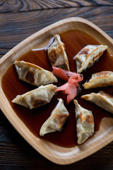 Poster - Bamboo tray with gyoza served in soy sauce, close-up