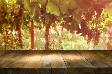 Wall Mural - image of wooden table in front of vineyard landscape