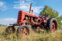 Red Old Rusty Tractor In A Field