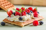 Fototapeta  - Closeup of waffle with whipped cream and berry fruits