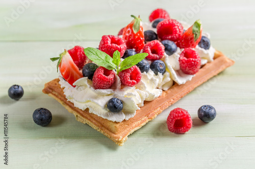 Fotografía Closeup of waffle with berry fruits and whipped cream
