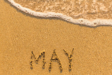 May - Written By Hand On A Golden Beach Sand.