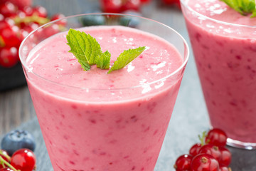 Wall Mural - milkshake with fresh berries and mint in glass, close-up