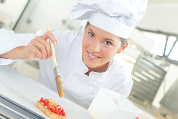 Baker brushing her pastries