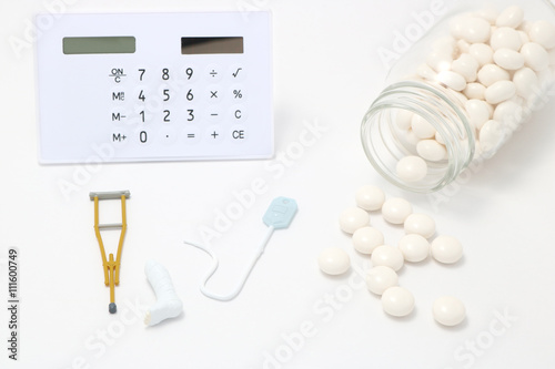 倒れた透明のビンからこぼれる白い薬と電卓とけが 病気イメージの小物 Stock Photo Adobe Stock