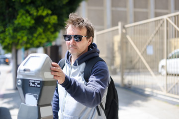 Man using street parking meter