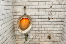 Filthy, Stained Urinal In The Toilet Of An Abandoned Prison.