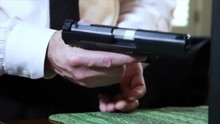Close Up Of A Man Inserting A Clip Into His Automatic Nine Millimeter Pistol And Then Checking The Slide. Hand Held Shot For Dramatic Effect.