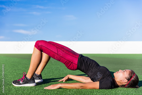 Foto Fitness Asian woman doing bodyweight glute exercises with floor bridge hip raise butt life leg exercise outdoor grass gym