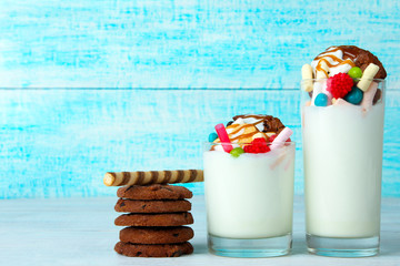 Wall Mural - a milkshake with a cocktail straw and biscuits with candies on wooden background