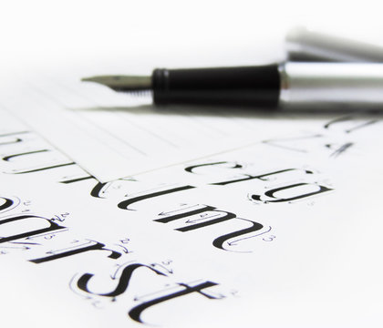 Fountain pen on lined paper and calligraphy document.