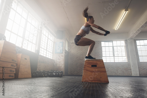 Fotografía Mujer que hace un cuadro en cuclillas en el gimnasio