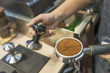© pomphotothailand - espresso pouring from coffee machine by professional coffee brewing.