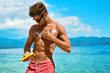 Man Skin Care In Summer. Handsome Male With Sexy Body In Sunglasses Applying UV Protective Sunscreen Lotion Before Sunbathing, Tanning At Beach Using Solar Sun Block Protection Cream For Healthy Tan.