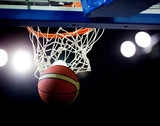 Fototapeta Sport - Basketball going through the hoop at a sports arena