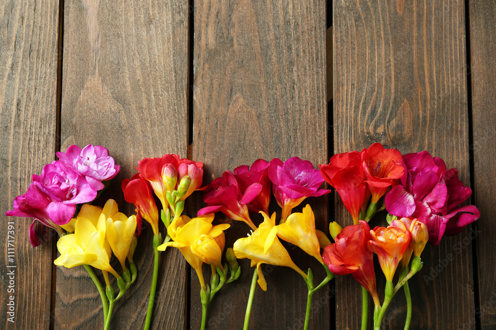 Beautiful freesia flowers on wooden background