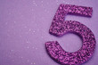 Number five purple color over a purple background. Anniversary