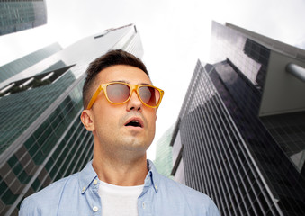 Poster - face of scared man in sunglasses over big city