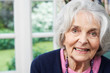 Head And Shoulders Portrait Of Smiling Senior Woman At Home
