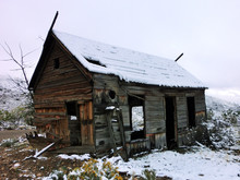 Abandoned Old Vintage Wooden Cabin Leaning In Decay In The Snow