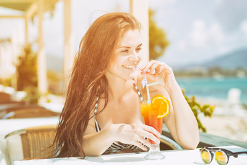 Wall Mural - Woman with cocktail in the beach bar during tropical vacation