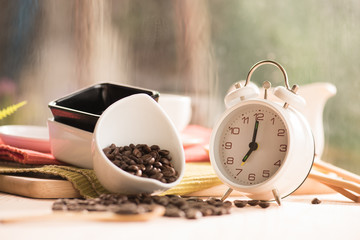 coffee beans and vintage alarm clock on a rainy day window backg