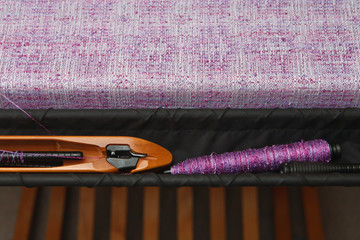 Wall Mural - Weaving shuttle with thread on the lilac warp