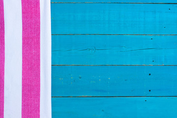 Wall Mural - Blank rustic teal blue wood beach sign with pink and white striped beach towel border