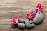 Fototapeta Kwiaty - Stones and red orchid on wooden background