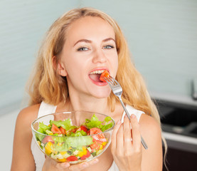 Young woman eating vegetable salad