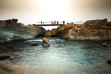 Wall Mural - People walk over the bridge between cliff rock.