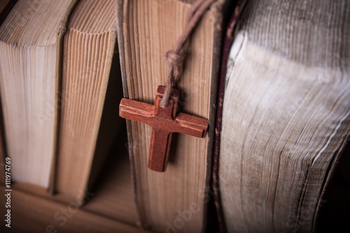 Plakat Closeup of wooden Christian cross necklace next to holy Bible