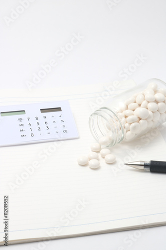 電卓と倒れた透明のビンからこぼれる白い錠剤とペン Buy This Stock Photo And Explore Similar Images At Adobe Stock Adobe Stock 電卓と倒れた透明のビンからこぼれる白い錠剤とペン Buy This Stock Photo And Explore Similar Images At Adobe Stock Adobe Stock