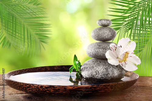 Foto-Kissen - Composition with spa stones and flower on natural blurred background (von Africa Studio)