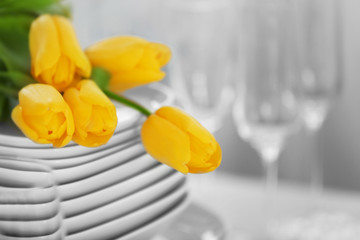 Canvas Print - Set of dishes with yellow tulips for dinner party, close up