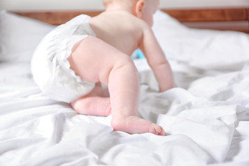 Wall Mural - Adorable baby crawling on parents bed, close up