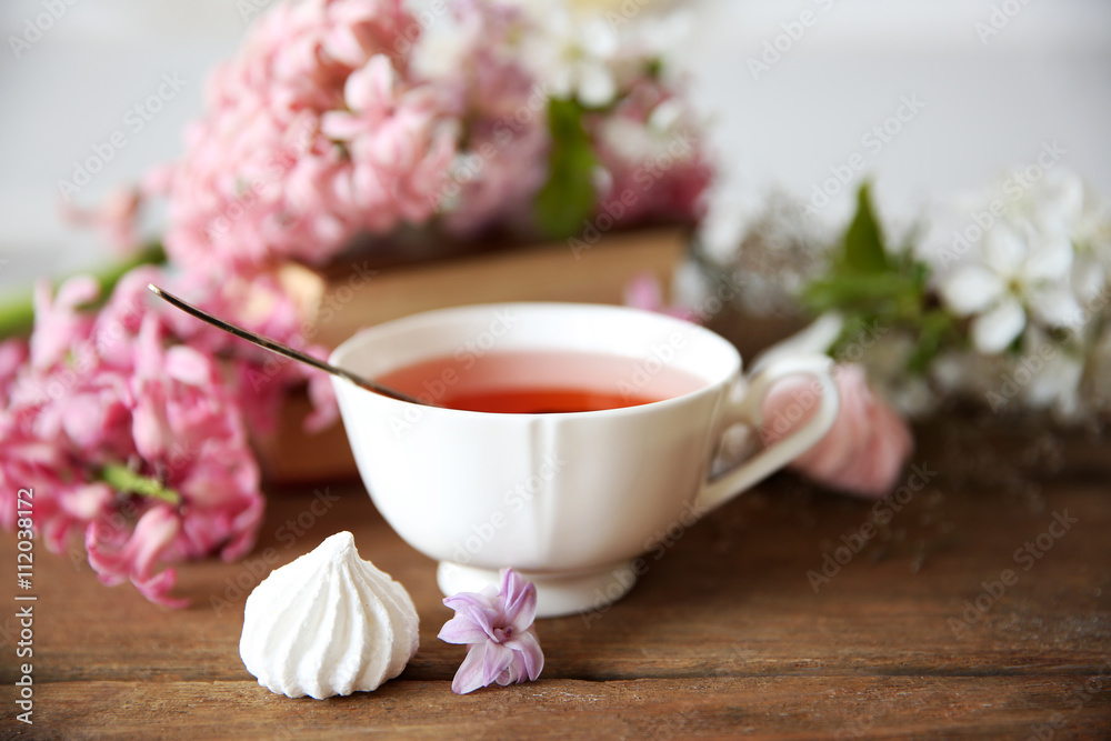 Cup of tea and flowers on wooden table