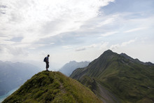 Man Standing On Top Of Mountain
