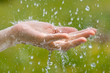 hand of woman catching raindrops, closeup