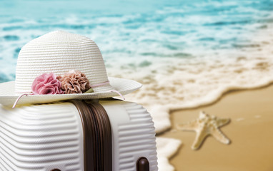 Hat on luggage at the beach