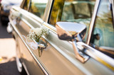 Fototapeta Kwiaty - Zabytkowy samochód do ślubu udekorowany kwiatami i wstążkami